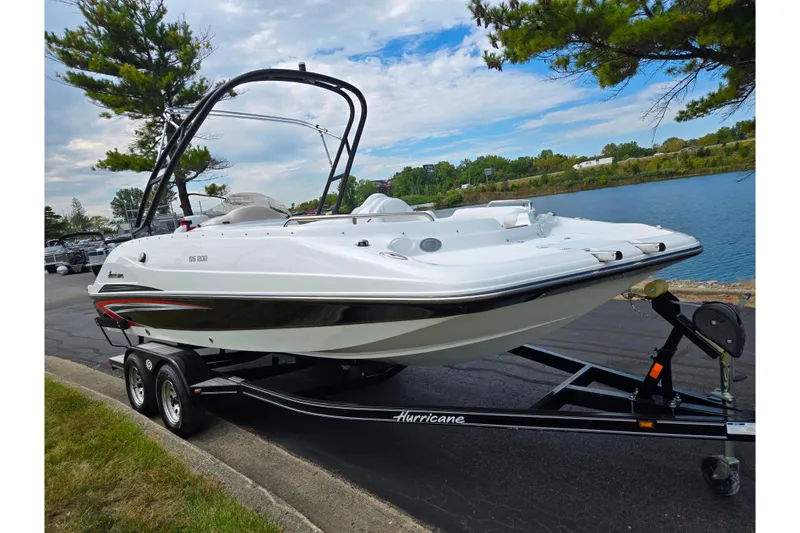 Slide: The Image of 2020 Hurricane SunDeck Sport 202 IO boat on trailer by a lake. - 8