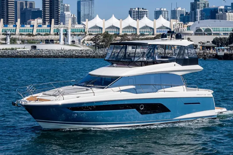 Slide: The Image of 2019 Prestige 520 yacht cruising near urban waterfront skyline. - 34