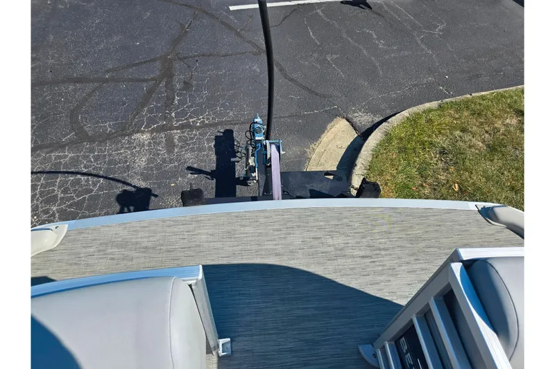 Slide: The Image of 2022 Bennington L 22 L-Bench pontoon boat on trailer in parking lot. - 22