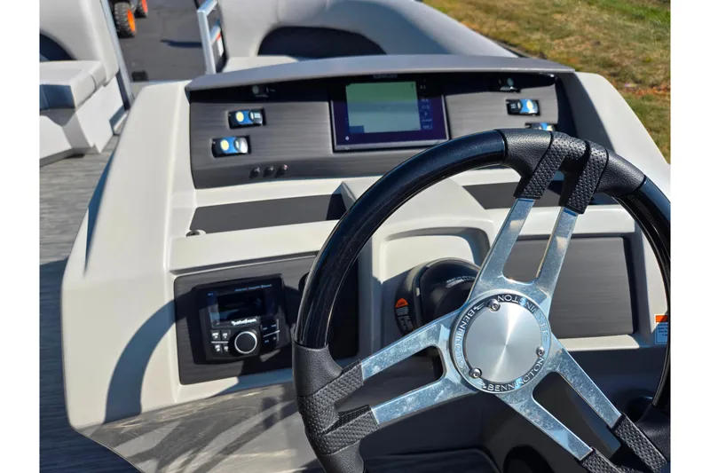 Slide: The Image of 2022 Bennington L 22 L-Bench boat dashboard with steering wheel and control panel. - 24