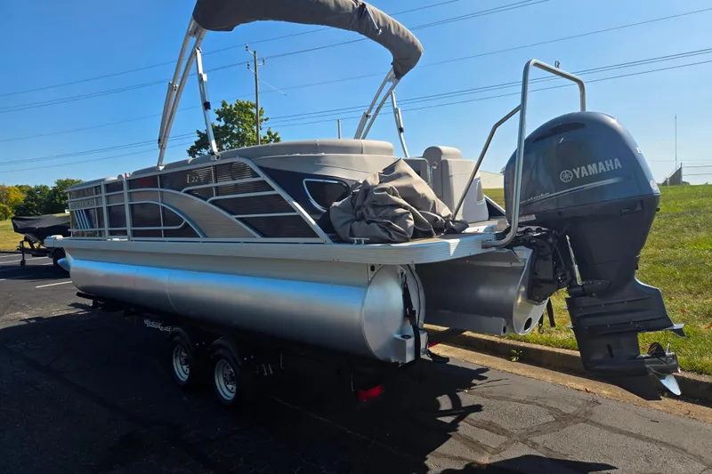 Slide: The Image of 2022 Bennington L 22 L-Bench pontoon boat with Yamaha outboard motor on trailer. - 3