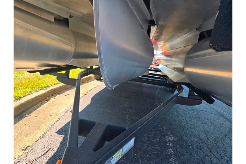 Slide: The Image of Underneath view of a 2022 Bennington L 22 L-Bench pontoon boat on a trailer. - 7