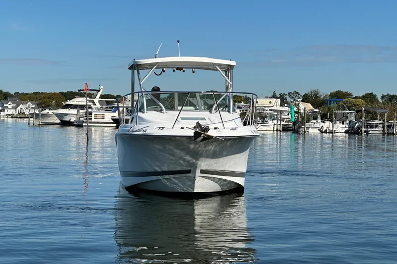 Slide: The Image of 2007 Wellcraft 252 Coastal boat on calm water, marina background, clear sky. - 1
