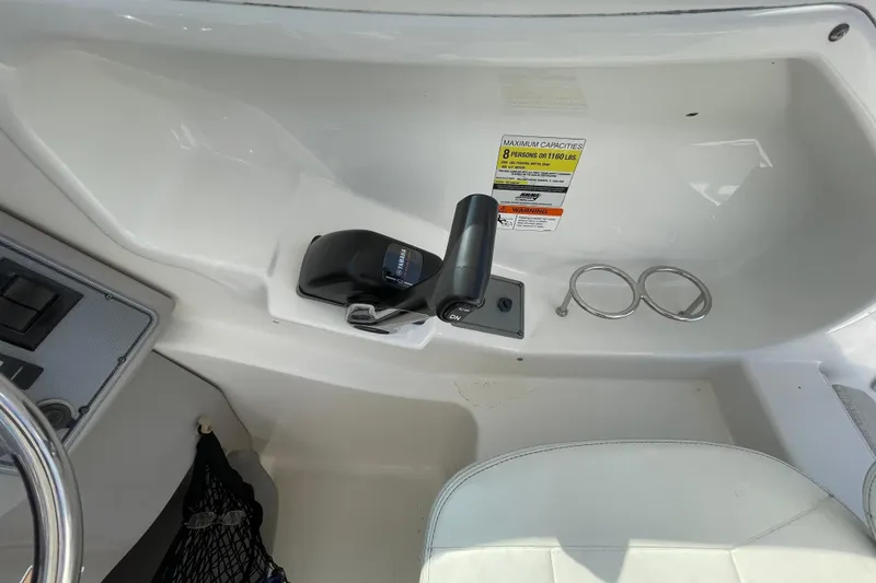 Slide: The Image of 2007 Wellcraft 252 Coastal boat cockpit with throttle control and capacity warning label. - 19