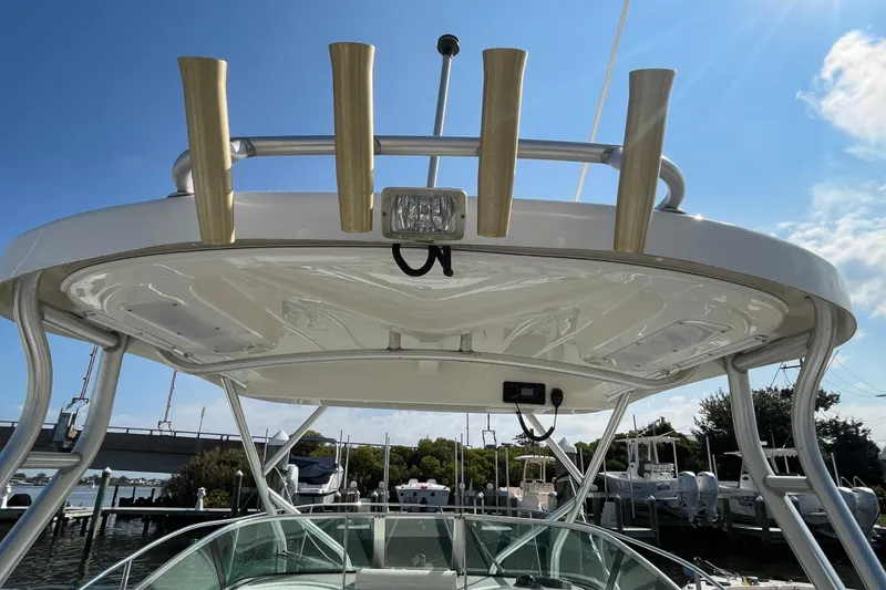 Slide: The Image of 2007 Wellcraft 252 Coastal boat with rod holders and canopy, docked under a sunny sky. - 35