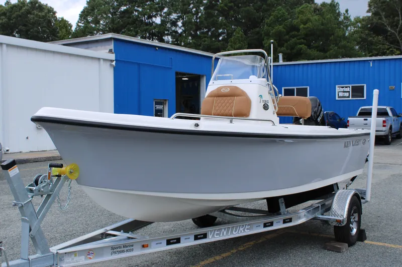 Slide: The Image of 2026 Key West 1720 Center Console boat on trailer, parked outside blue building. - 6