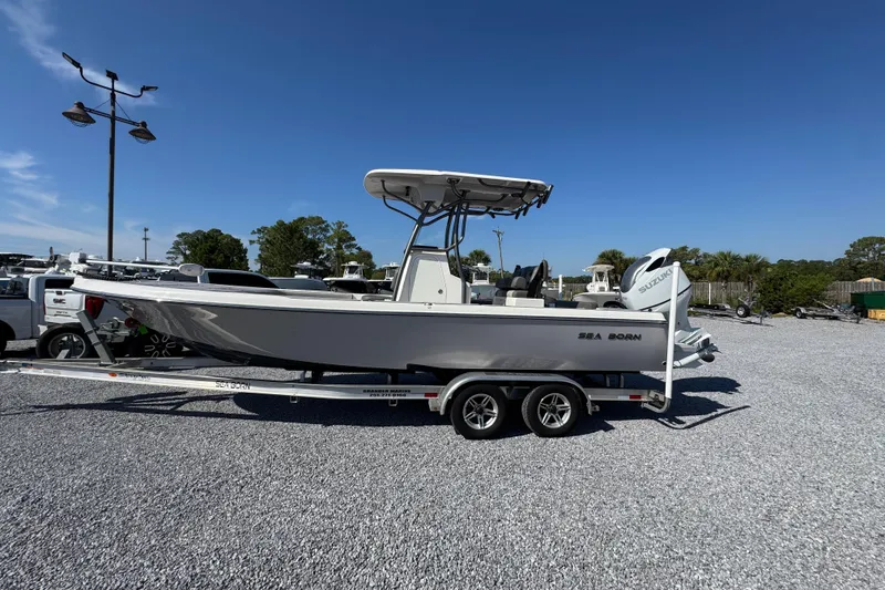 The Image of 2022 Sea Born FX25 Bay boat on trailer, parked outdoors under clear blue sky. - 1