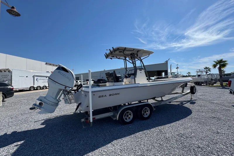 Slide: The Image of 2022 Sea Born FX25 Bay boat on trailer, parked outdoors under clear blue sky. - 10