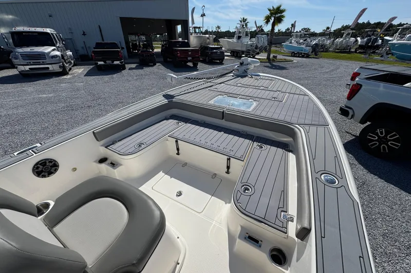 Slide: The Image of 2022 Sea Born FX25 Bay boat interior with seating and storage, parked outdoors. - 17