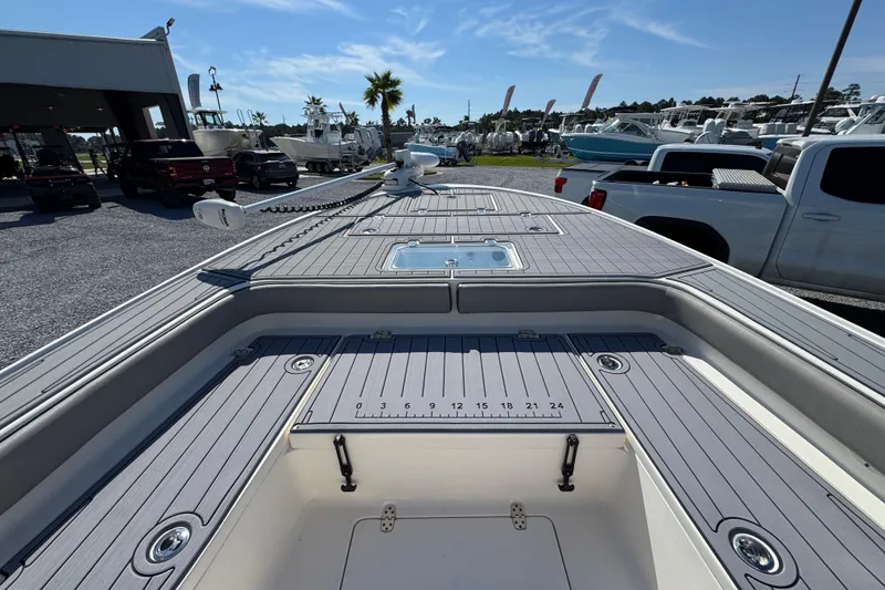 Slide: The Image of 2022 Sea Born FX25 Bay boat deck with storage compartments and ruler, parked outdoors. - 18