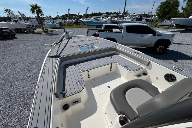 Slide: The Image of 2022 Sea Born FX25 Bay boat interior with seating and deck, parked near vehicles. - 19