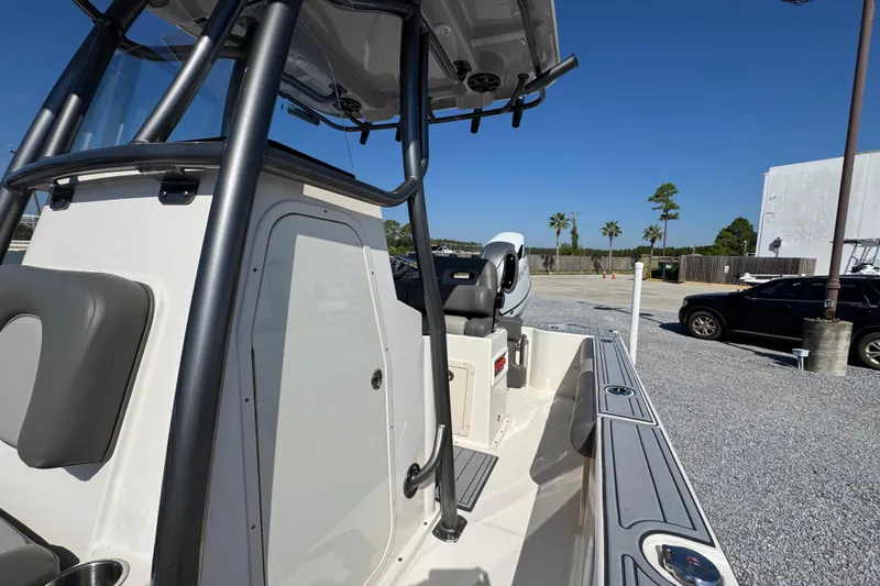 Slide: The Image of 2022 Sea Born FX25 Bay boat, interior view with seating and console, parked outdoors. - 24