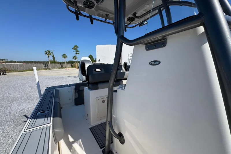 Slide: The Image of 2022 Sea Born FX25 Bay boat interior with seating and console, under clear blue sky. - 25