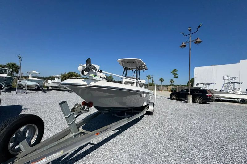 Slide: The Image of 2022 Sea Born FX25 Bay boat on trailer under clear blue sky. - 4