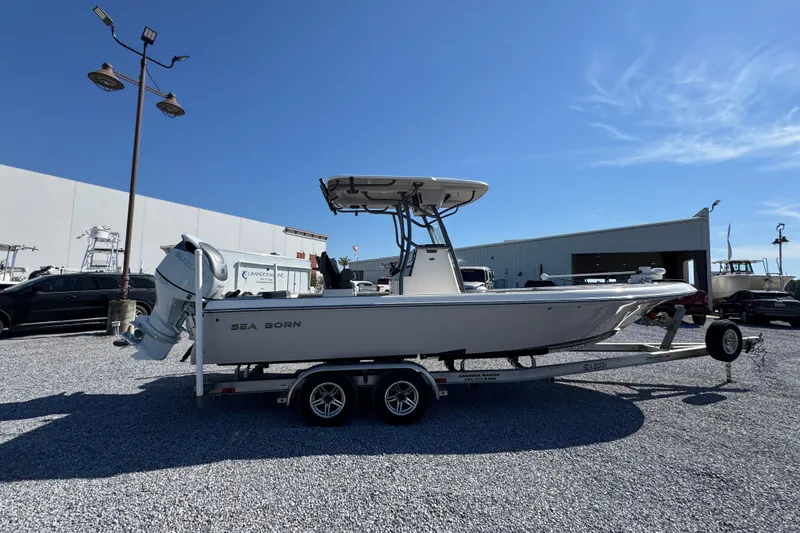 Slide: The Image of 2022 Sea Born FX25 Bay boat on trailer, parked outdoors under clear blue sky. - 9
