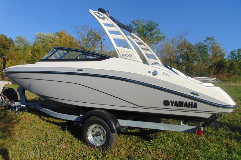 The Image of 2026 Yamaha Boats 195S on trailer, sleek design, parked on grass. - 11