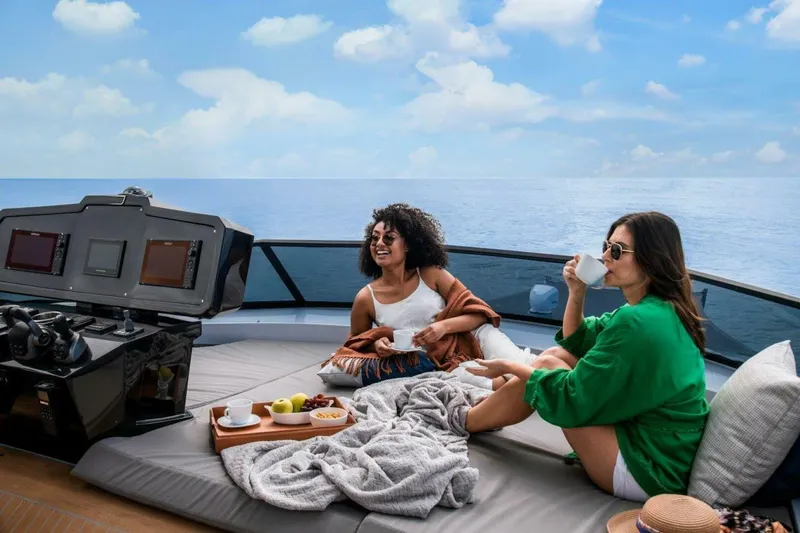 Slide: The Image of Two people relaxing on a luxurious 2025 OKEAN 52 yacht, enjoying drinks and snacks. - 41