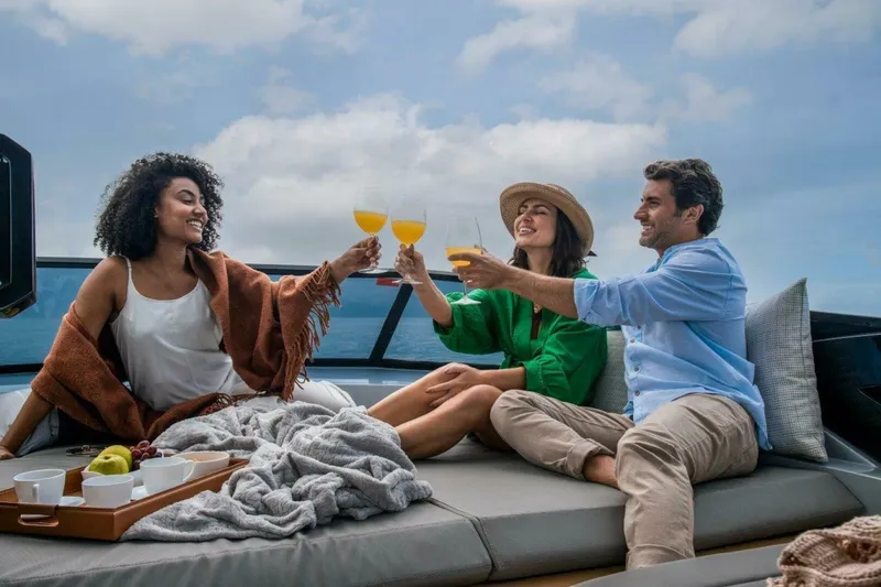 Slide: The Image of Three people toasting on a luxurious 2025 OKEAN 52 yacht. - 44