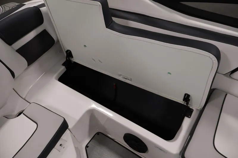 Slide: The Image of 2026 Yamaha Boats AR195 interior storage compartment with open seat and sleek design. - 30