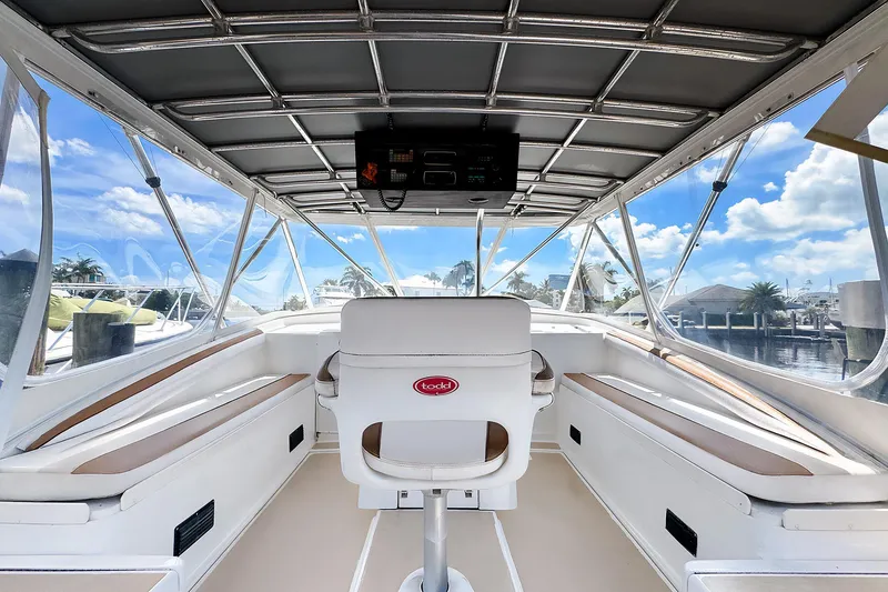 Slide: The Image of 1994 Luhrs 38 boat interior with helm, seating, and panoramic marina view. - 11