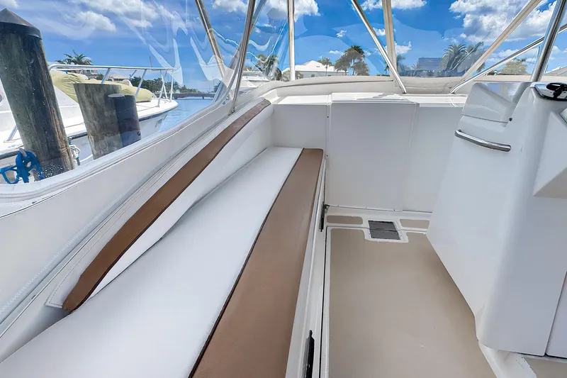 Slide: The Image of 1994 Luhrs 38 boat interior with cushioned seating and clear windows. - 13