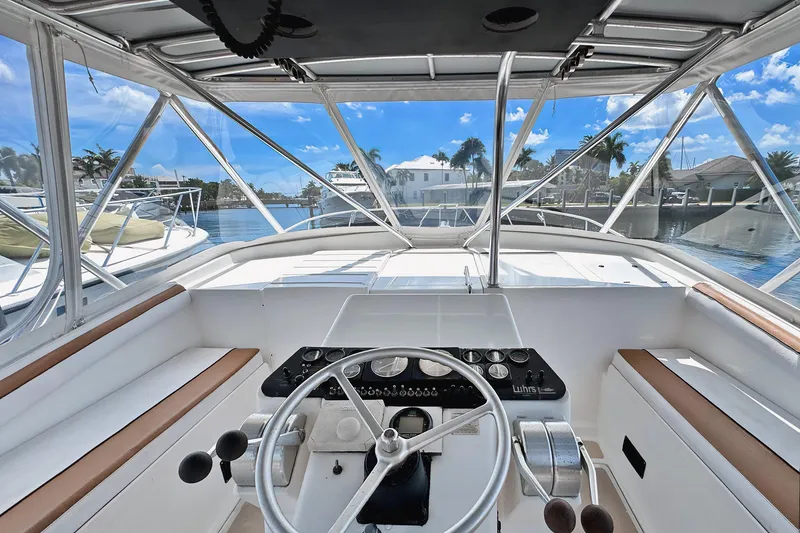 Slide: The Image of 1994 Luhrs 38 boat helm with steering wheel, controls, and marina view. - 17