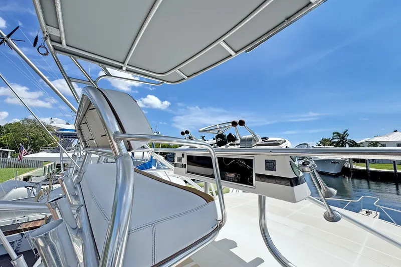 Slide: The Image of 1994 Luhrs 38 yacht helm with controls, docked under clear blue sky. - 20