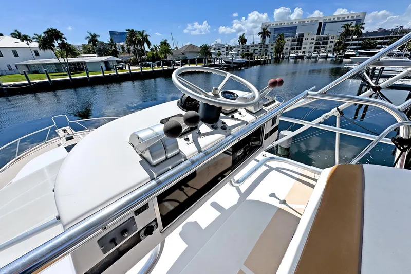 Slide: The Image of 1994 Luhrs 38 boat helm with steering wheel, dockside view, sunny day, palm trees, waterfront buildings. - 21