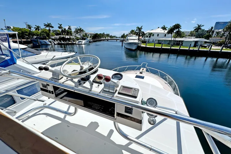 Slide: The Image of 1994 Luhrs 38 yacht helm with marina view, featuring steering wheel and navigation controls. - 23
