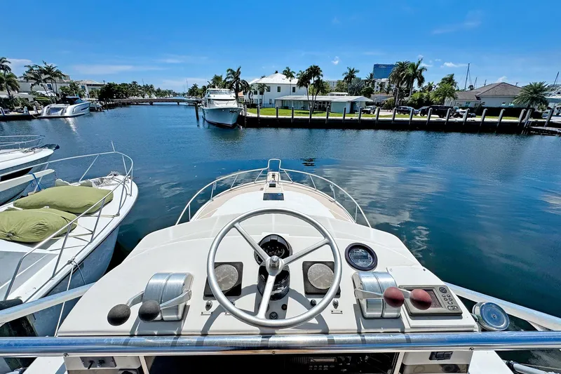 Slide: The Image of 1994 Luhrs 38 boat helm view, docked in a sunny marina with palm trees. - 24
