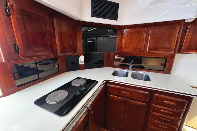 Slide: The Image of Luxurious 1994 Luhrs 38 yacht kitchen with wood cabinets and modern appliances. - 31