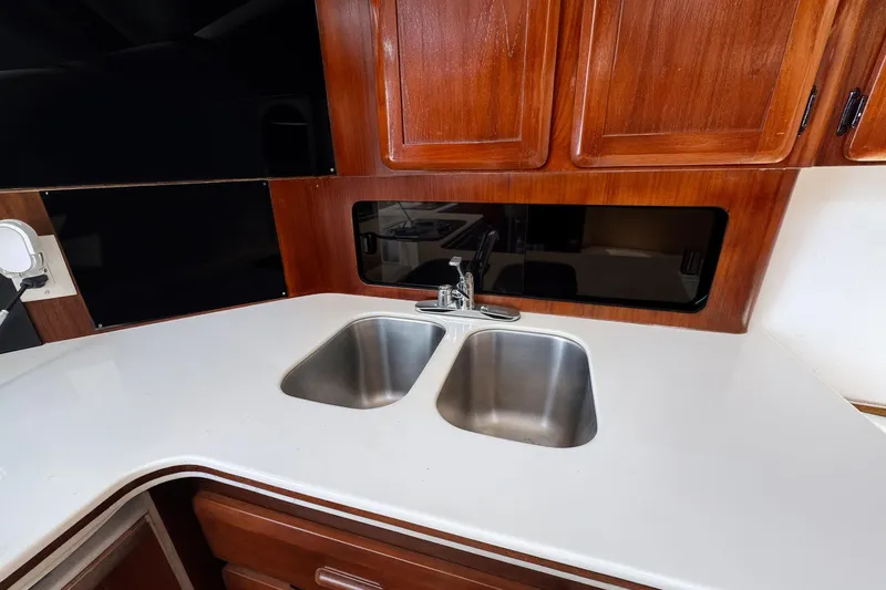 Slide: The Image of 1994 Luhrs 38 yacht kitchen with dual sinks and wooden cabinetry. - 32