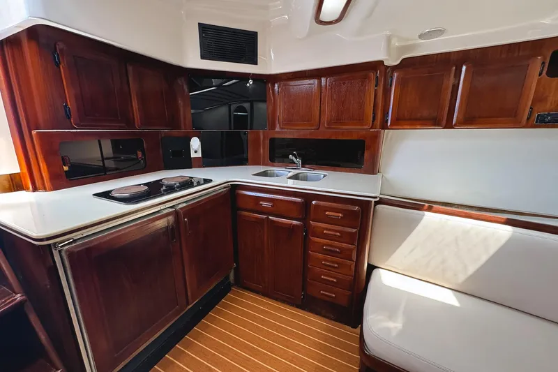 Slide: The Image of Luxurious 1994 Luhrs 38 yacht interior with wooden cabinetry and modern kitchen amenities. - 34