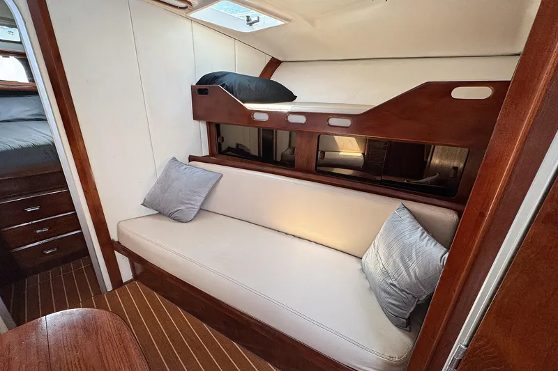 Slide: The Image of 1994 Luhrs 38 yacht interior with bunk bed, sofa, and wooden accents. - 36