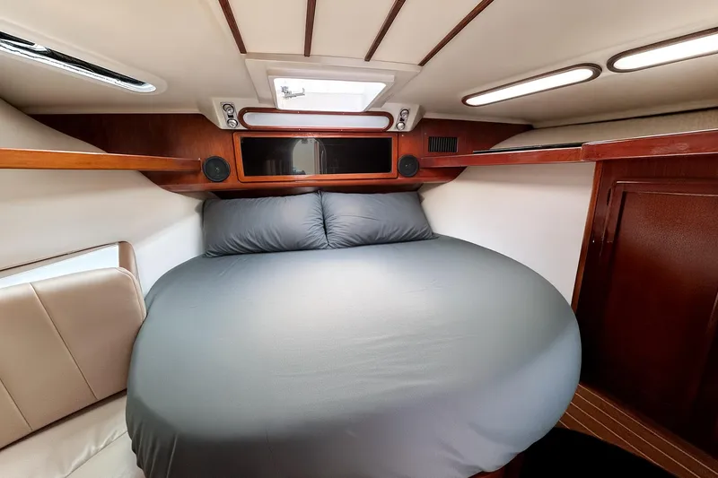 Slide: The Image of 1994 Luhrs 38 boat cabin interior with cozy bed and wooden accents. - 37