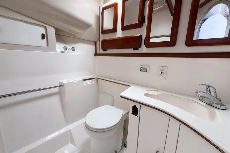 Slide: The Image of Bathroom interior of 1994 Luhrs 38 boat with sink, toilet, and wooden cabinets. - 38