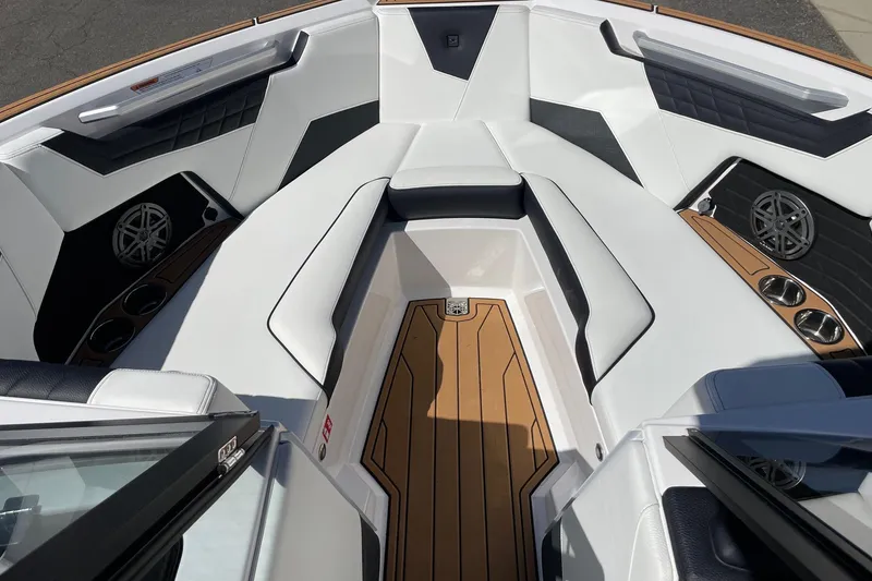 Slide: The Image of 2026 Nautique Super Air Nautique S23 boat interior with white seating and wood accents. - 11