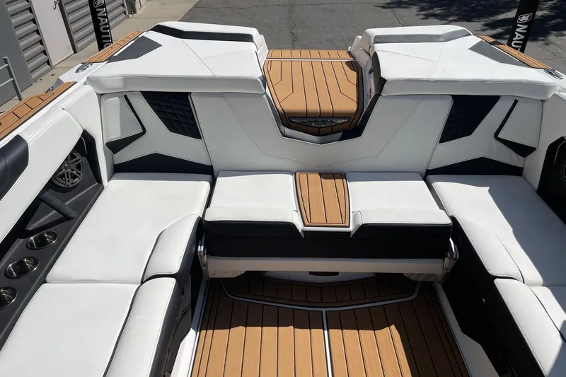 Slide: The Image of 2026 Nautique Super Air Nautique S23 interior with luxurious seating and teak flooring. - 8