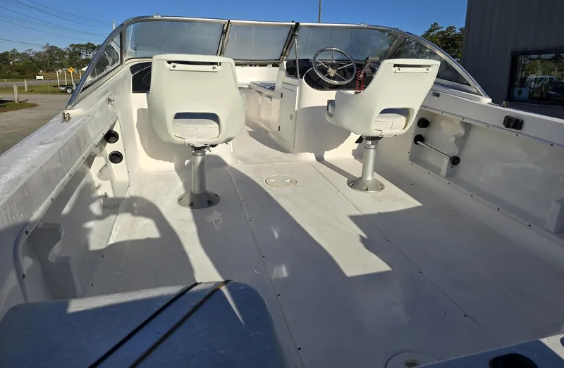 Slide: The Image of 2002 Angler 180DC boat interior with dual white seats and steering wheel. - 5