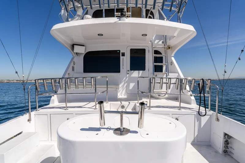Slide: The Image of Hatteras 70 Convertible 2000 yacht deck with fishing equipment, ocean view, and clear sky. - 10