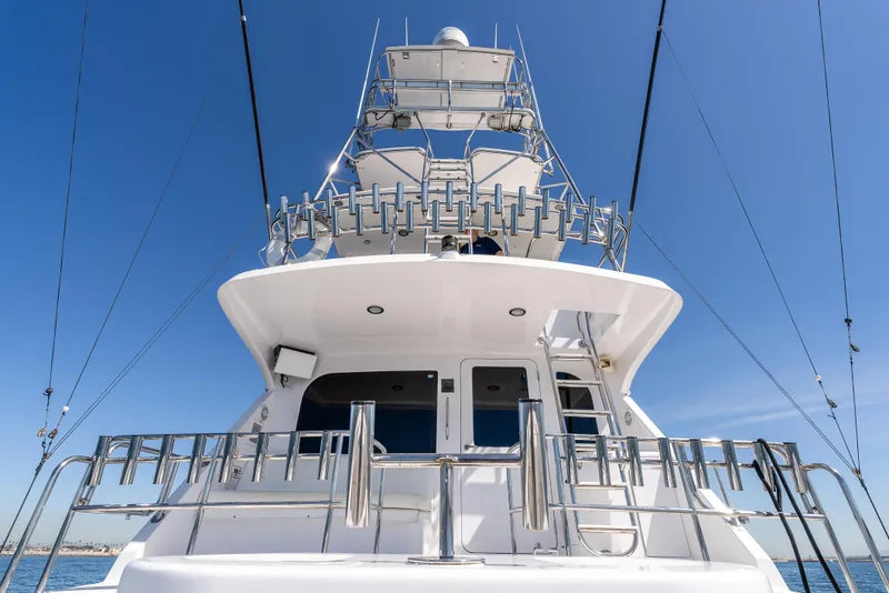 Slide: The Image of Hatteras 70 Convertible yacht, 2000 model, viewed from the stern under a clear blue sky. - 12