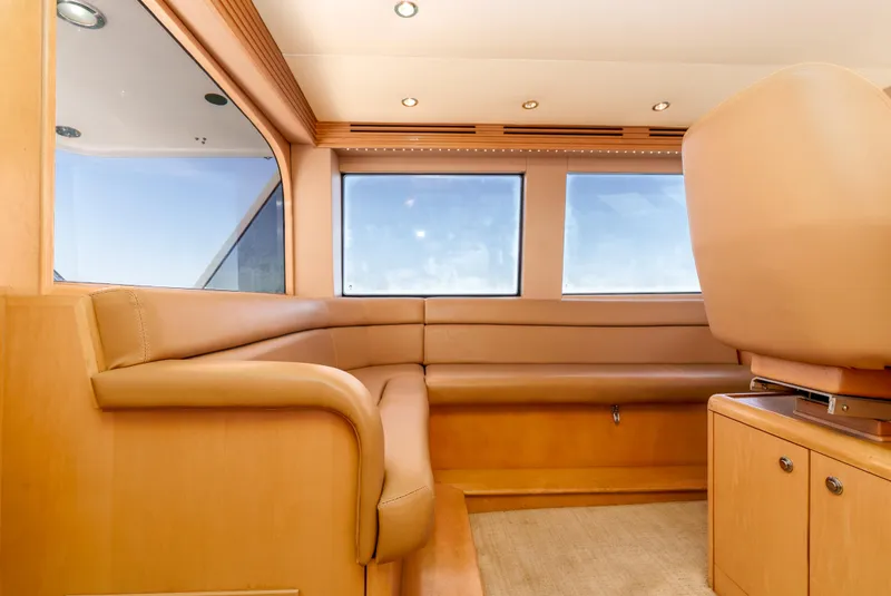 Slide: The Image of Interior of 2000 Hatteras 70 Convertible yacht with beige leather seating and large windows. - 18