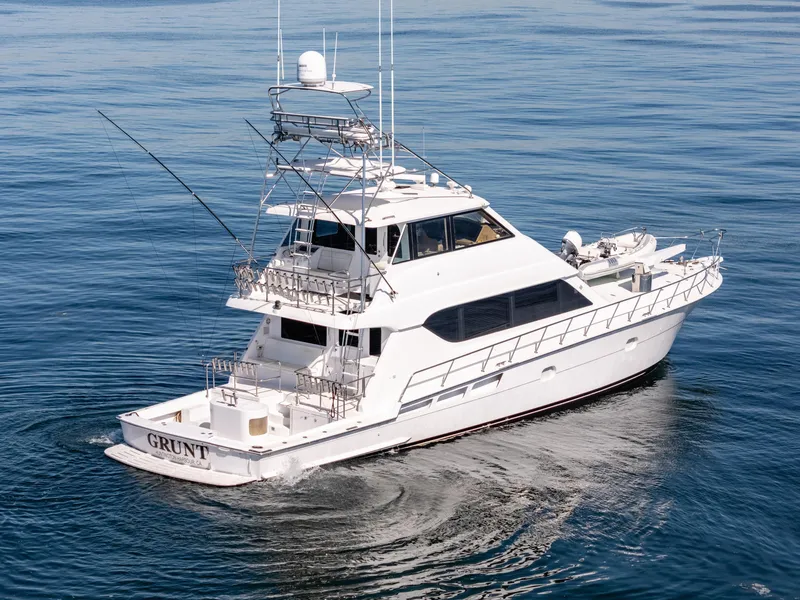 Slide: The Image of 2000 Hatteras 70 Convertible yacht cruising on calm blue waters. - 2
