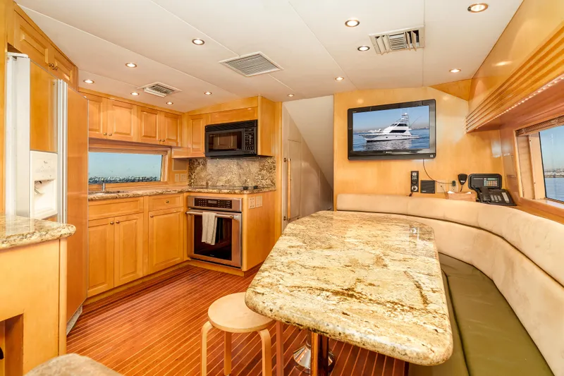 Slide: The Image of Luxurious kitchen interior of 2000 Hatteras 70 Convertible yacht with granite countertops and wood flooring. - 25