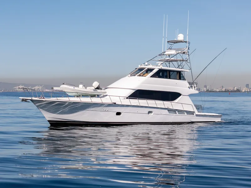 Slide: The Image of Hatteras 70 Convertible yacht, 2000 model, cruising on calm waters with city skyline backdrop. - 3