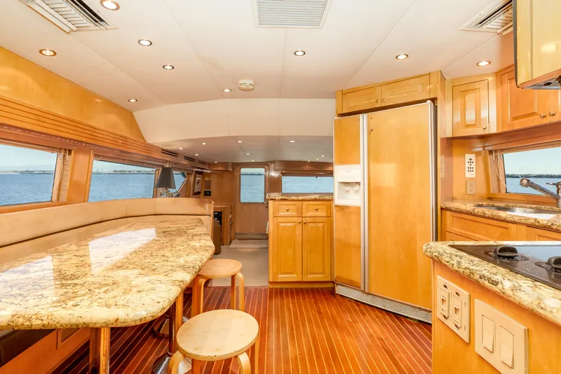 Slide: The Image of Luxurious interior of 2000 Hatteras 70 Convertible yacht with wood finishes and granite countertops. - 31