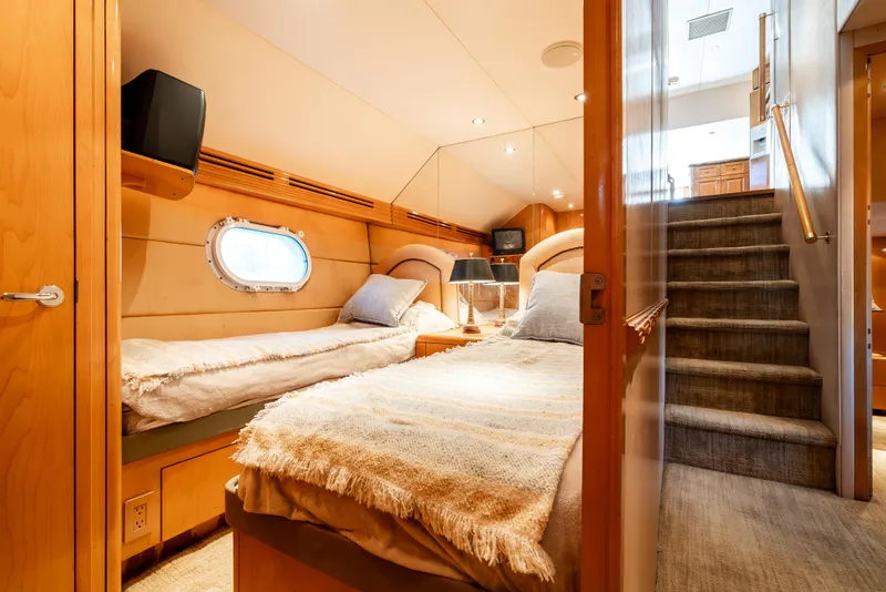 Slide: The Image of Luxurious cabin interior of 2000 Hatteras 70 Convertible yacht with twin beds and porthole. - 37