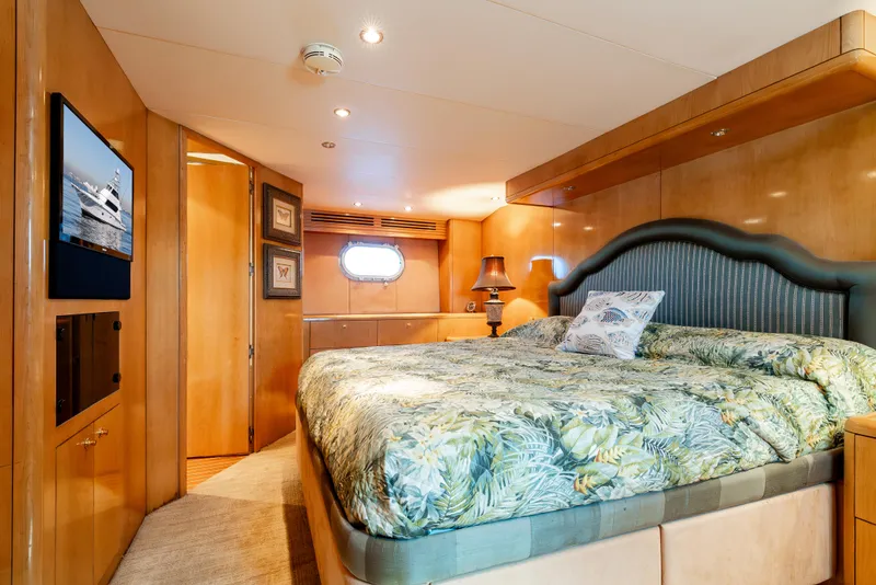 Slide: The Image of Luxurious bedroom interior of 2000 Hatteras 70 Convertible yacht with elegant wood paneling. - 42