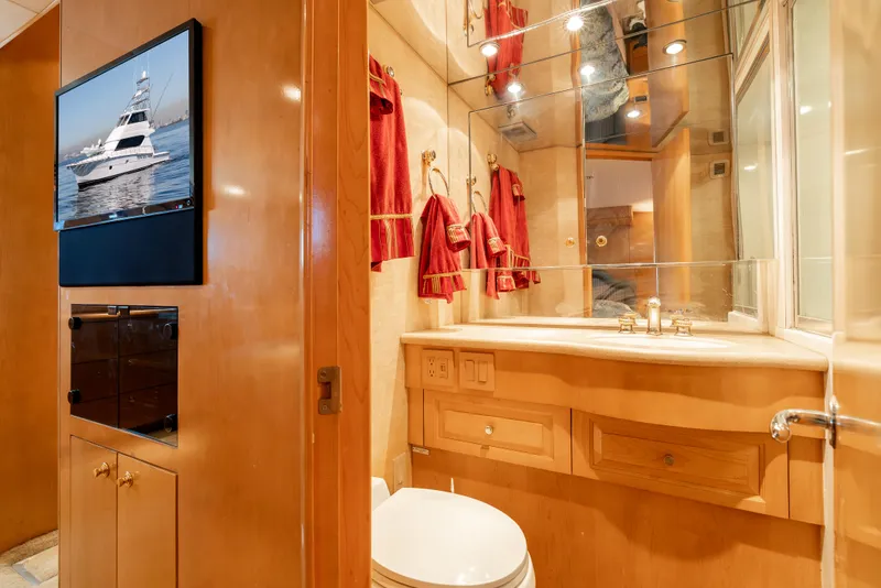 Slide: The Image of Luxurious bathroom interior of 2000 Hatteras 70 Convertible yacht with wooden cabinetry and red accents. - 44