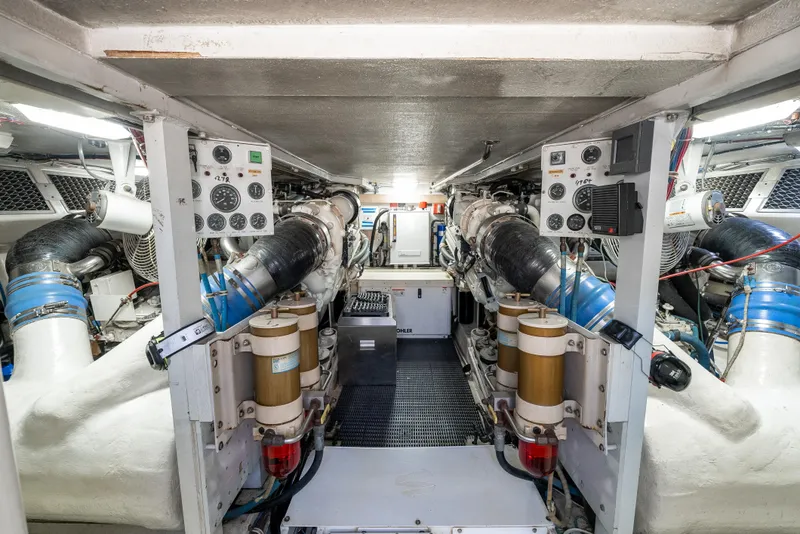 Slide: The Image of Engine room of 2000 Hatteras 70 Convertible yacht, showcasing dual engines and control panels. - 47
